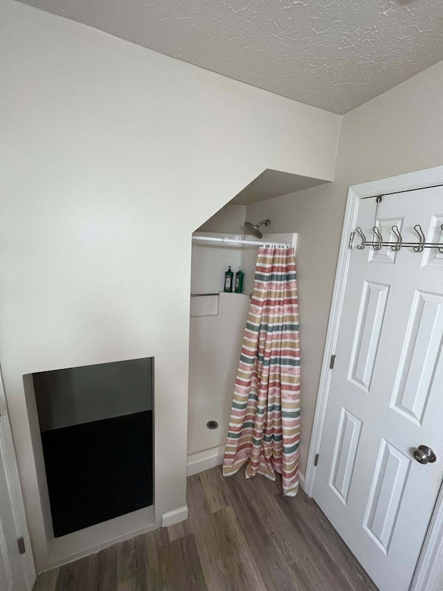 bedroom featuring a textured ceiling and dark hardwood / wood-style flooring
