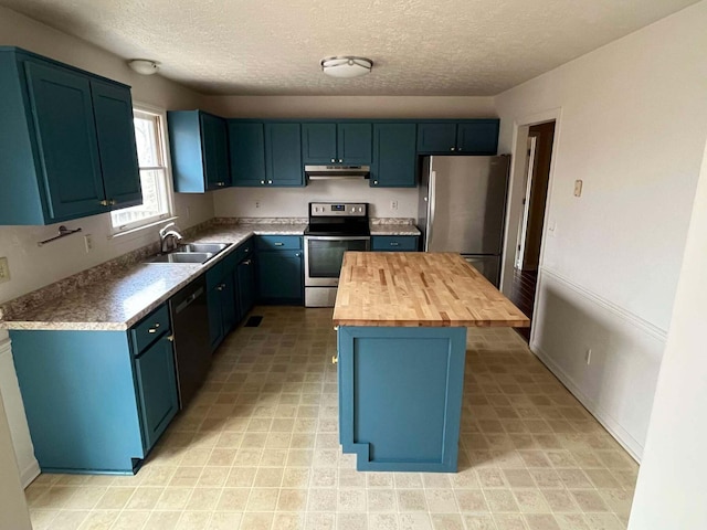 kitchen with butcher block countertops, sink, a kitchen island, stainless steel appliances, and blue cabinets