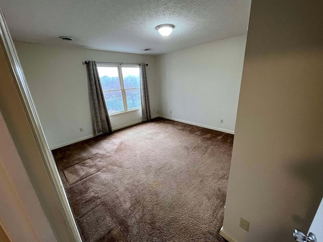 spare room featuring carpet flooring and a textured ceiling