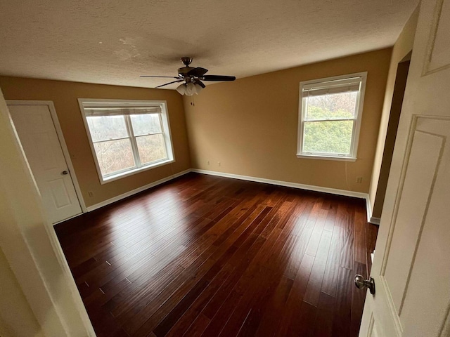 spare room with ceiling fan, dark hardwood / wood-style floors, and a textured ceiling