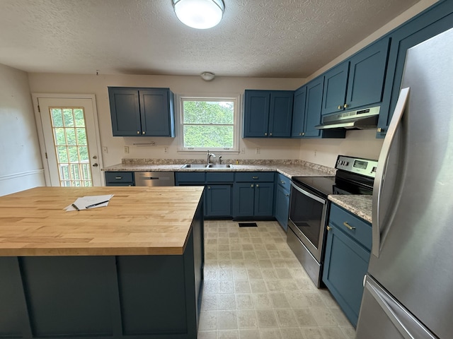 968 Cedar Trace Ln, Morristown, TN 37814 - kitchen featuring stainless steel appliances, under cabinet range hood, blue cabinets, a textured ceiling, and butcher block counters