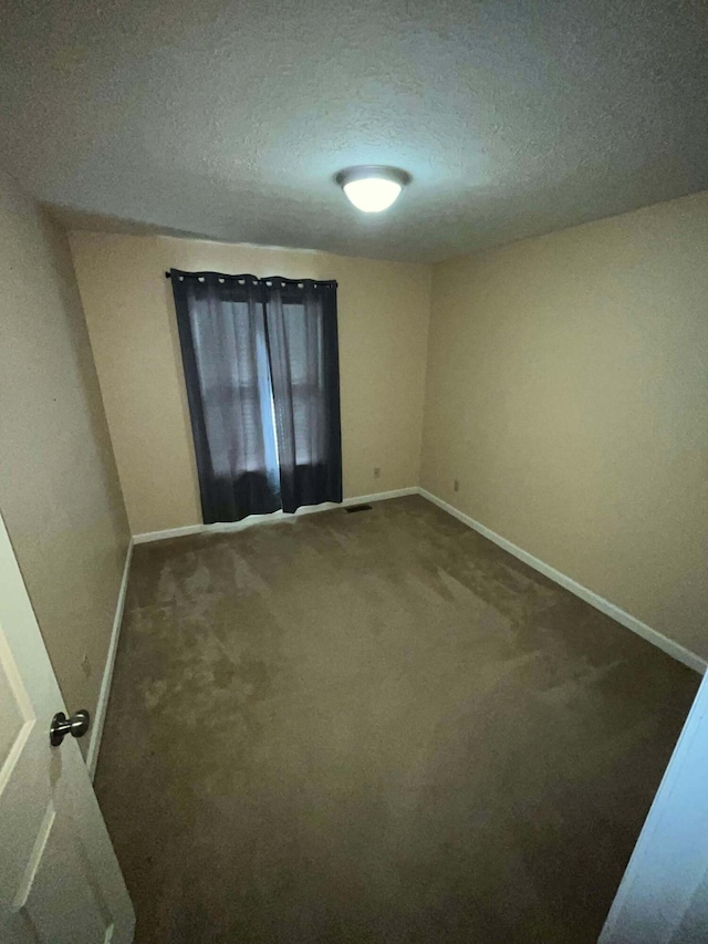 carpeted empty room with a textured ceiling