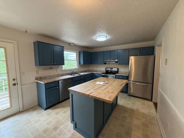 968 Cedar Trace Ln, Morristown, TN 37814 - kitchen with appliances with stainless steel finishes, wooden counters, under cabinet range hood, blue cabinets, and a textured ceiling