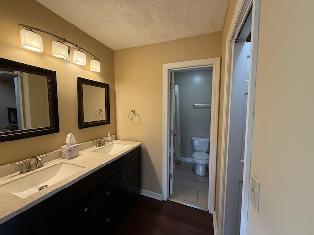 968 Cedar Trace Ln, Morristown, TN 37814 - bathroom with wood finished floors, double vanity, toilet, a textured ceiling, and baseboards