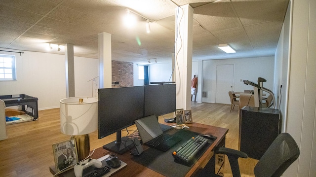 office featuring a drop ceiling, wood finished floors, and track lighting