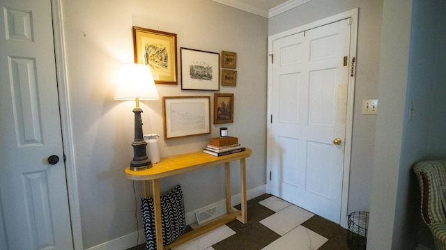 entryway with crown molding, baseboards, and tile patterned floors