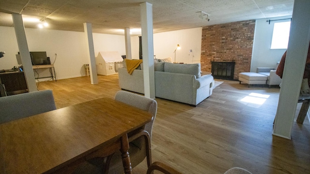 interior space with a brick fireplace and wood finished floors