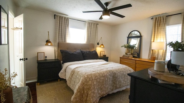 bedroom featuring multiple windows, a textured ceiling, and a ceiling fan