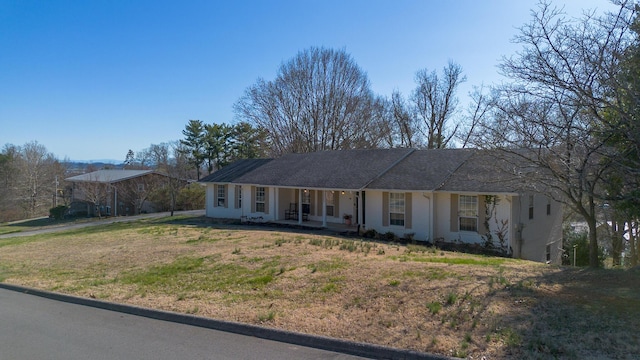 ranch-style home with covered porch and a front yard