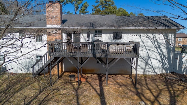 rear view of house featuring stairs, a wooden deck, brick siding, and a chimney