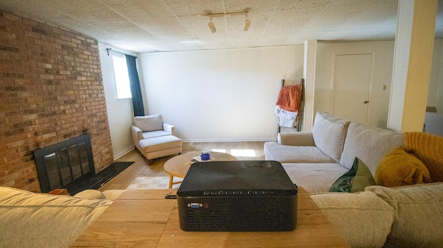 living area featuring a fireplace, wood finished floors, and baseboards