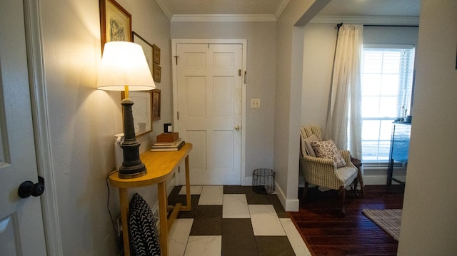 entrance foyer with crown molding, wood finished floors, a healthy amount of sunlight, and baseboards