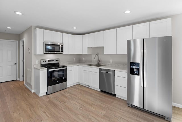 1002 Watercrest St, Morristown, TN 37814 - kitchen with stainless steel appliances, light countertops, light wood-type flooring, white cabinetry, and recessed lighting