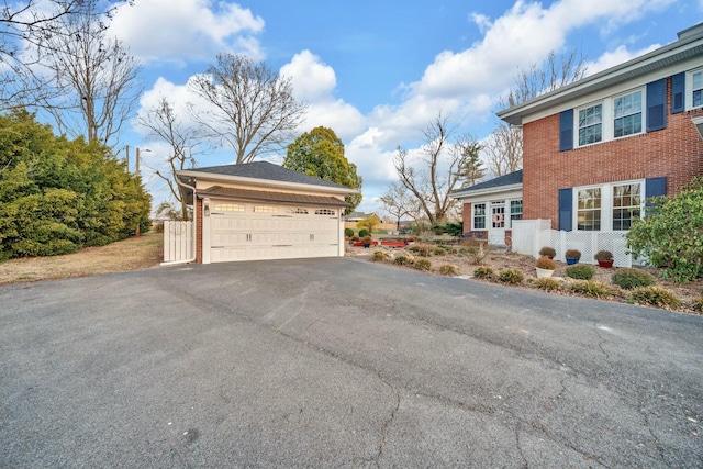 view of property exterior featuring brick siding and a detached garage