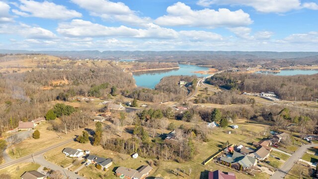 birds eye view of property featuring a forest view and a water view
