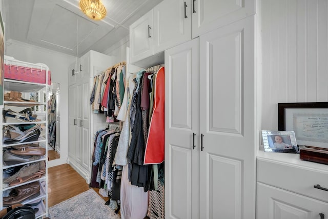 spacious closet with attic access and wood finished floors