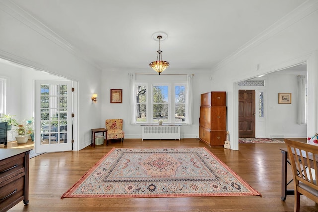 interior space with radiator heating unit, baseboard heating, wood finished floors, and crown molding