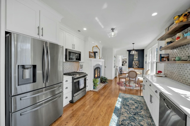 kitchen with white cabinets, stainless steel appliances, decorative backsplash, open shelves, and light countertops