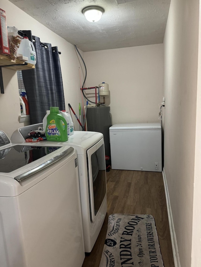 clothes washing area featuring water heater, dark wood-type flooring, a textured ceiling, and independent washer and dryer