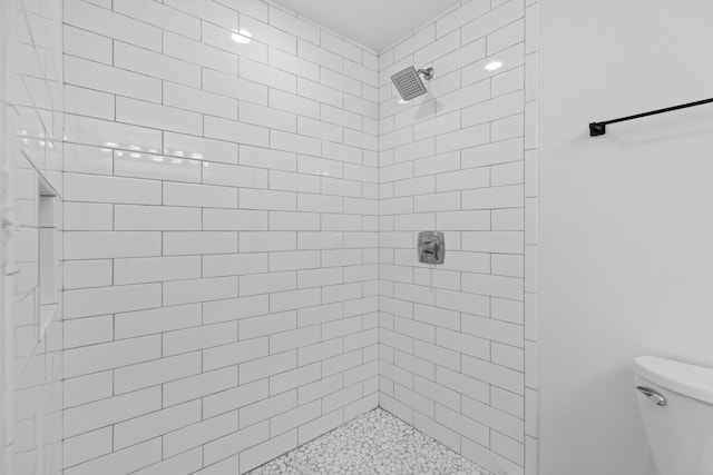 bathroom with toilet and a tile shower