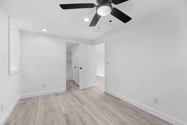 unfurnished bedroom featuring ceiling fan, light wood-type flooring, a spacious closet, and a closet