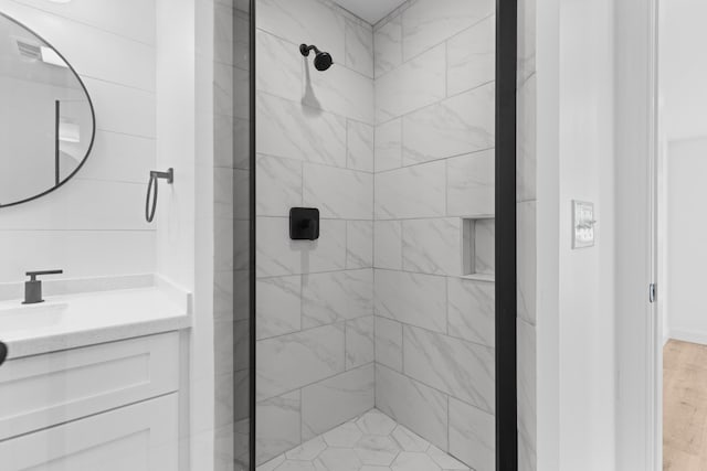 bathroom with vanity and a tile shower