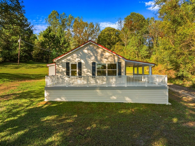 back of property with a lawn and a deck