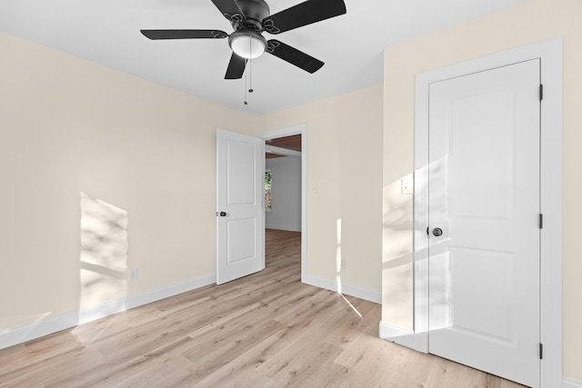 unfurnished bedroom with a closet, light hardwood / wood-style flooring, and ceiling fan