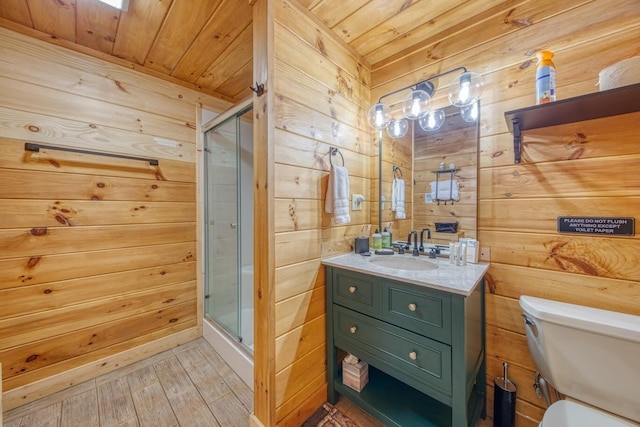 bathroom featuring wooden walls, wood ceiling, a shower stall, toilet, and vanity