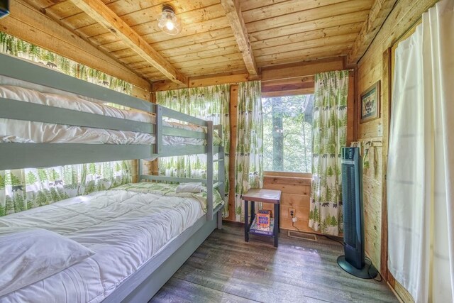 bedroom with wooden ceiling, wood finished floors, beamed ceiling, and wooden walls