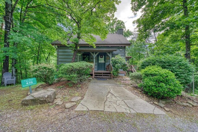 view of front of property featuring a chimney and covered porch