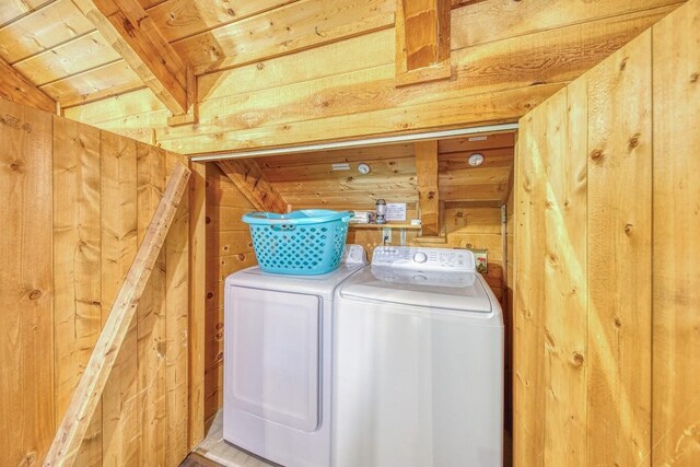 laundry room with washer and dryer, wood walls, and wooden ceiling