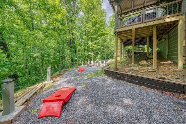 view of yard with a wooden deck and a wooded view