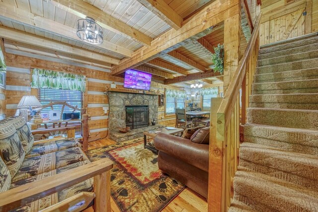 living room featuring wood ceiling, a chandelier, wooden walls, stairs, and plenty of natural light