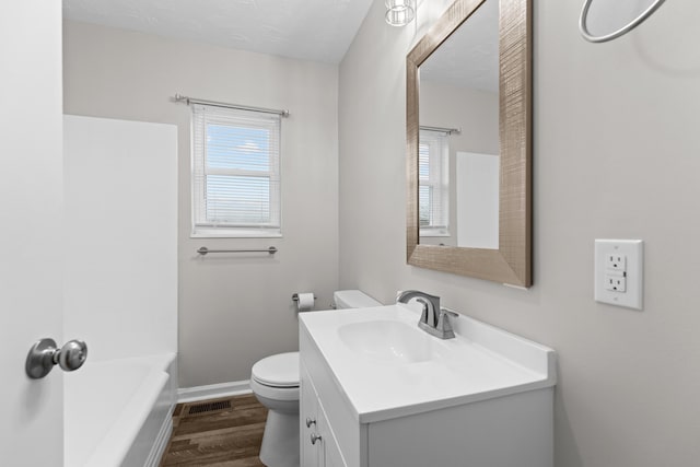 full bathroom featuring hardwood / wood-style flooring, vanity, tub / shower combination, and toilet