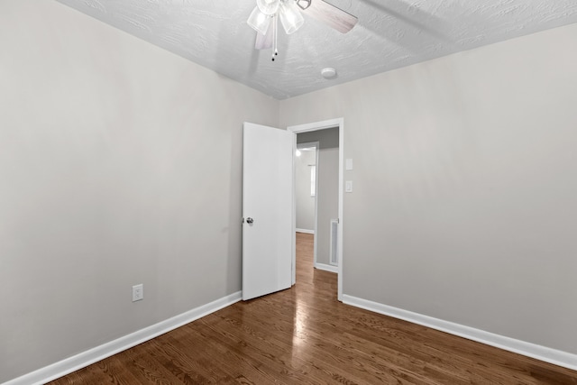 empty room with hardwood / wood-style floors, a textured ceiling, and ceiling fan