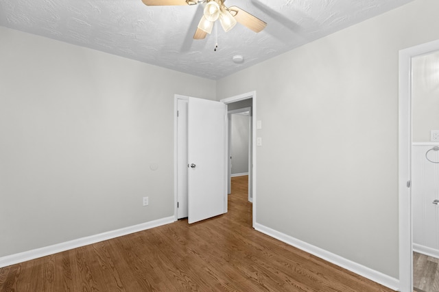 unfurnished bedroom with ceiling fan, hardwood / wood-style floors, and a textured ceiling