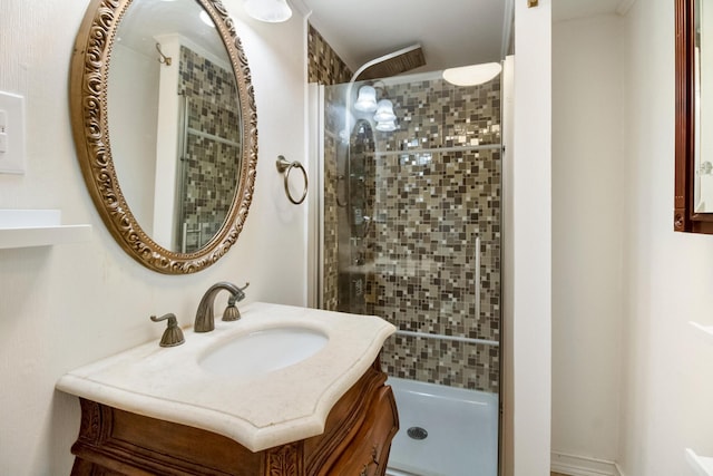 bathroom with a tile shower and vanity