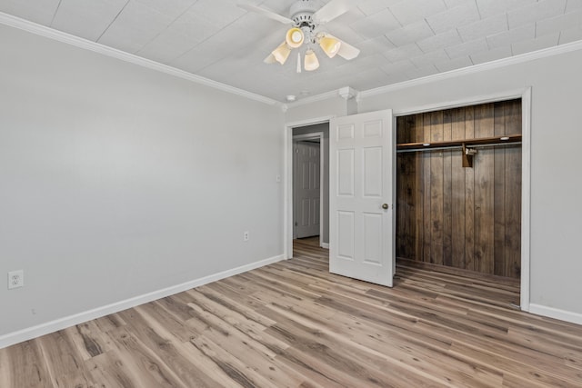 unfurnished bedroom featuring ceiling fan, light hardwood / wood-style floors, a closet, and crown molding