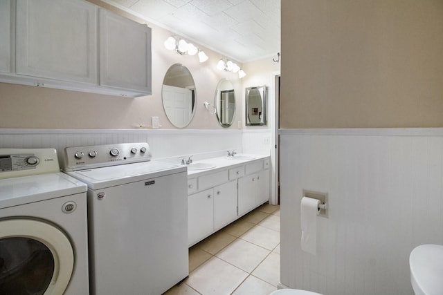 bathroom featuring sink, tile patterned flooring, ornamental molding, wood walls, and washer and dryer