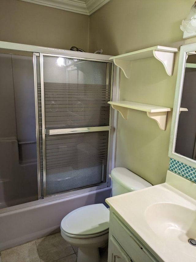 full bathroom featuring vanity, tile patterned floors, bath / shower combo with glass door, toilet, and ornamental molding