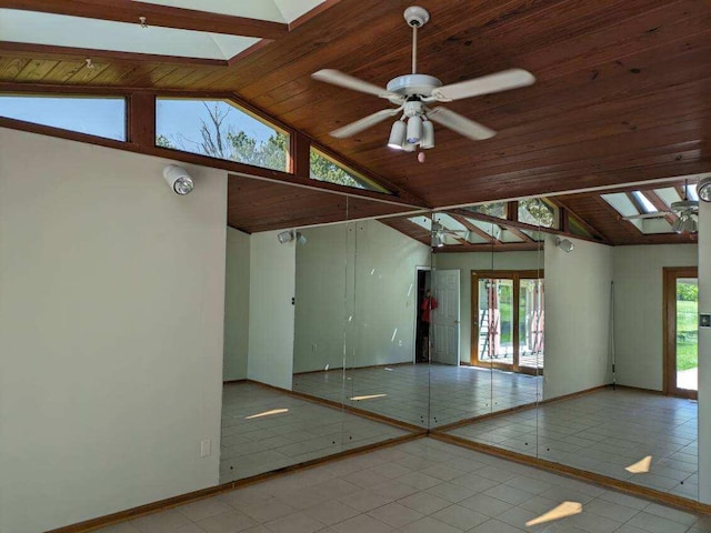 tiled spare room with a skylight, ceiling fan, high vaulted ceiling, and wood ceiling