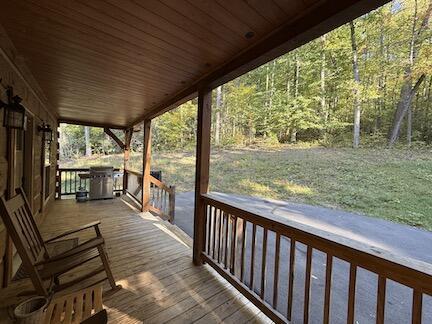 wooden deck featuring grilling area, a yard, and covered porch