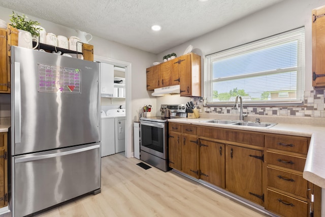 2121 Fir St, Morristown, TN 37813 - kitchen featuring appliances with stainless steel finishes, separate washer and dryer, under cabinet range hood, a sink, and light wood finished floors