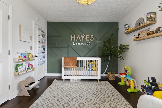 2121 Fir St, Morristown, TN 37813 - bedroom featuring a nursery area, wood finished floors, a textured ceiling, baseboards, and a decorative wall