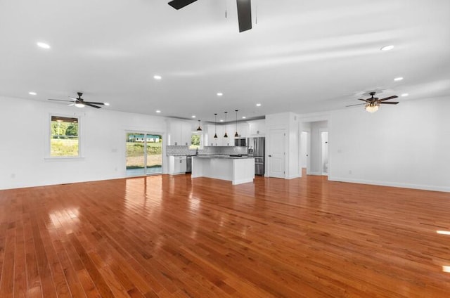 unfurnished living room featuring light wood-type flooring and ceiling fan