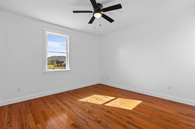 empty room with hardwood / wood-style floors and ceiling fan