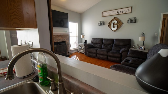 living room with hardwood / wood-style floors, lofted ceiling, and a fireplace