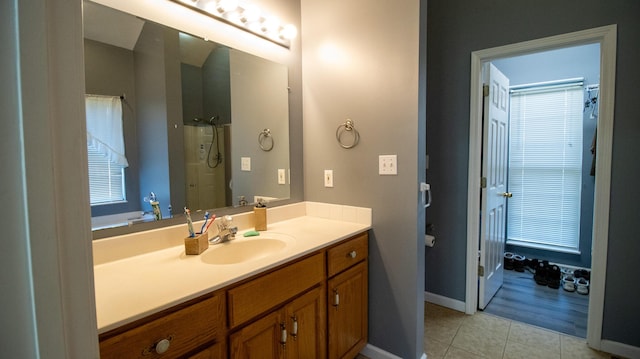 bathroom with tile patterned flooring, a shower, and vanity