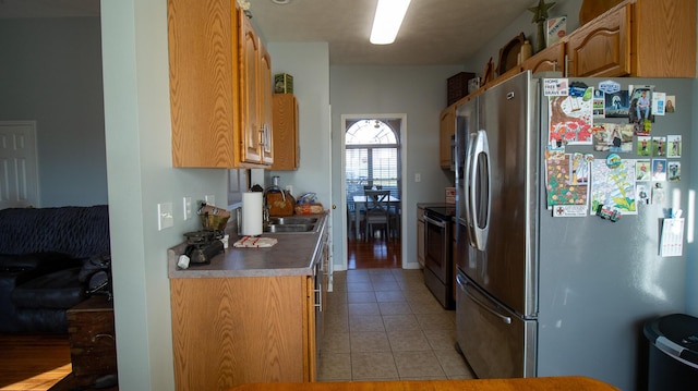 kitchen with appliances with stainless steel finishes, light tile patterned floors, and sink